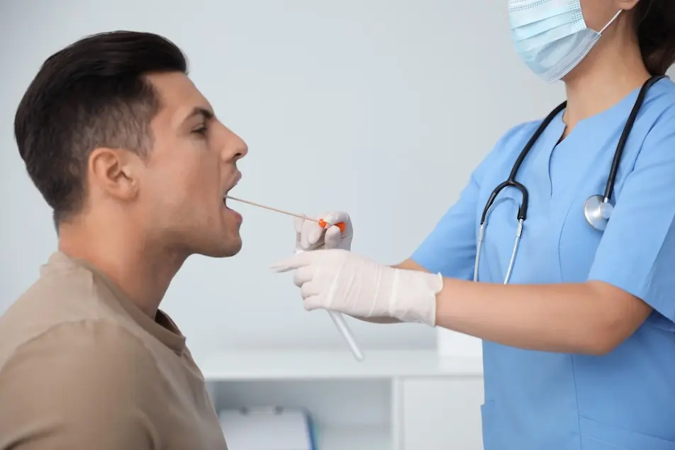 Doctor swabbing mouth of male patient