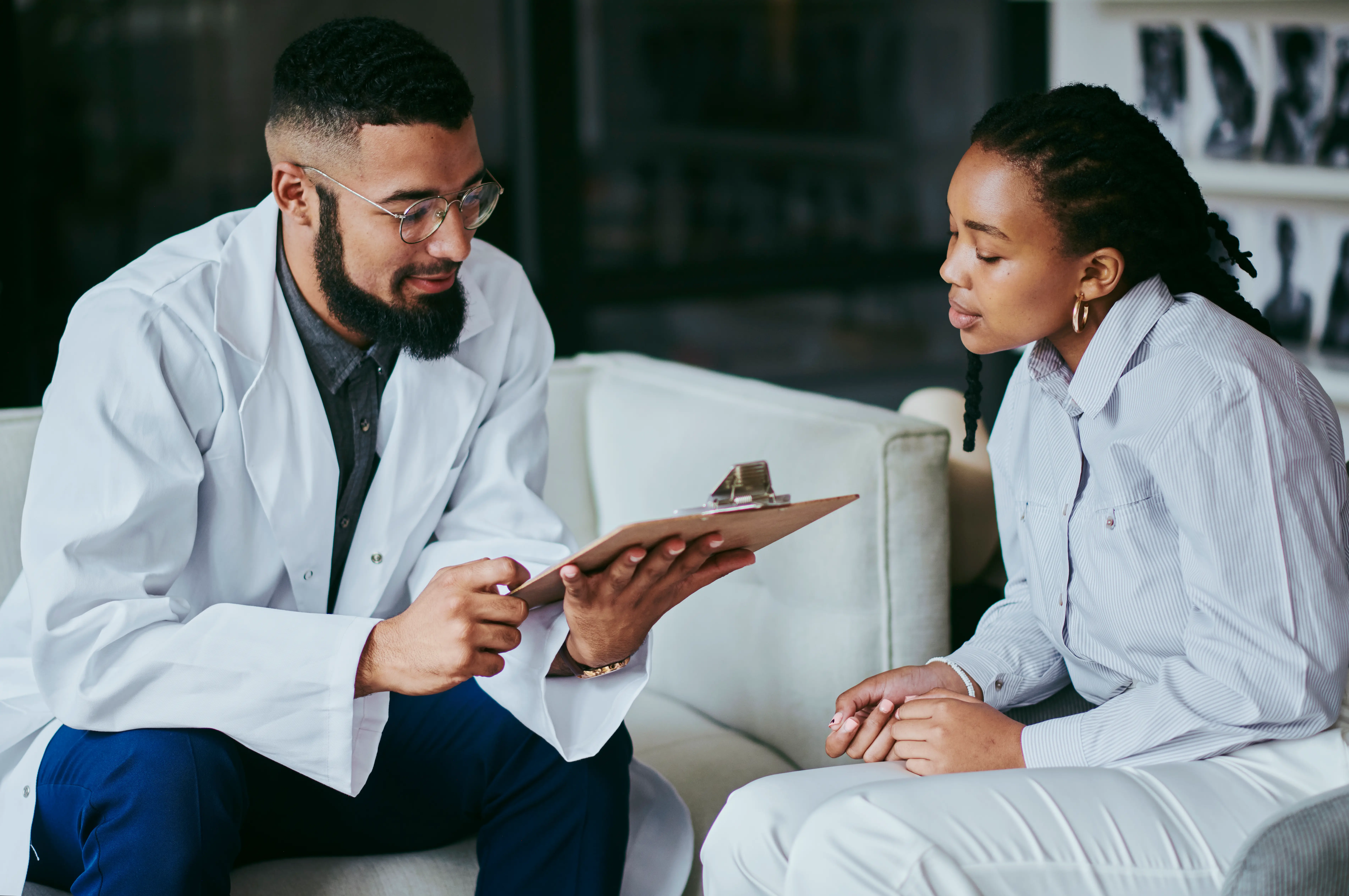 Patient looking at papers on a clipboard with doctor