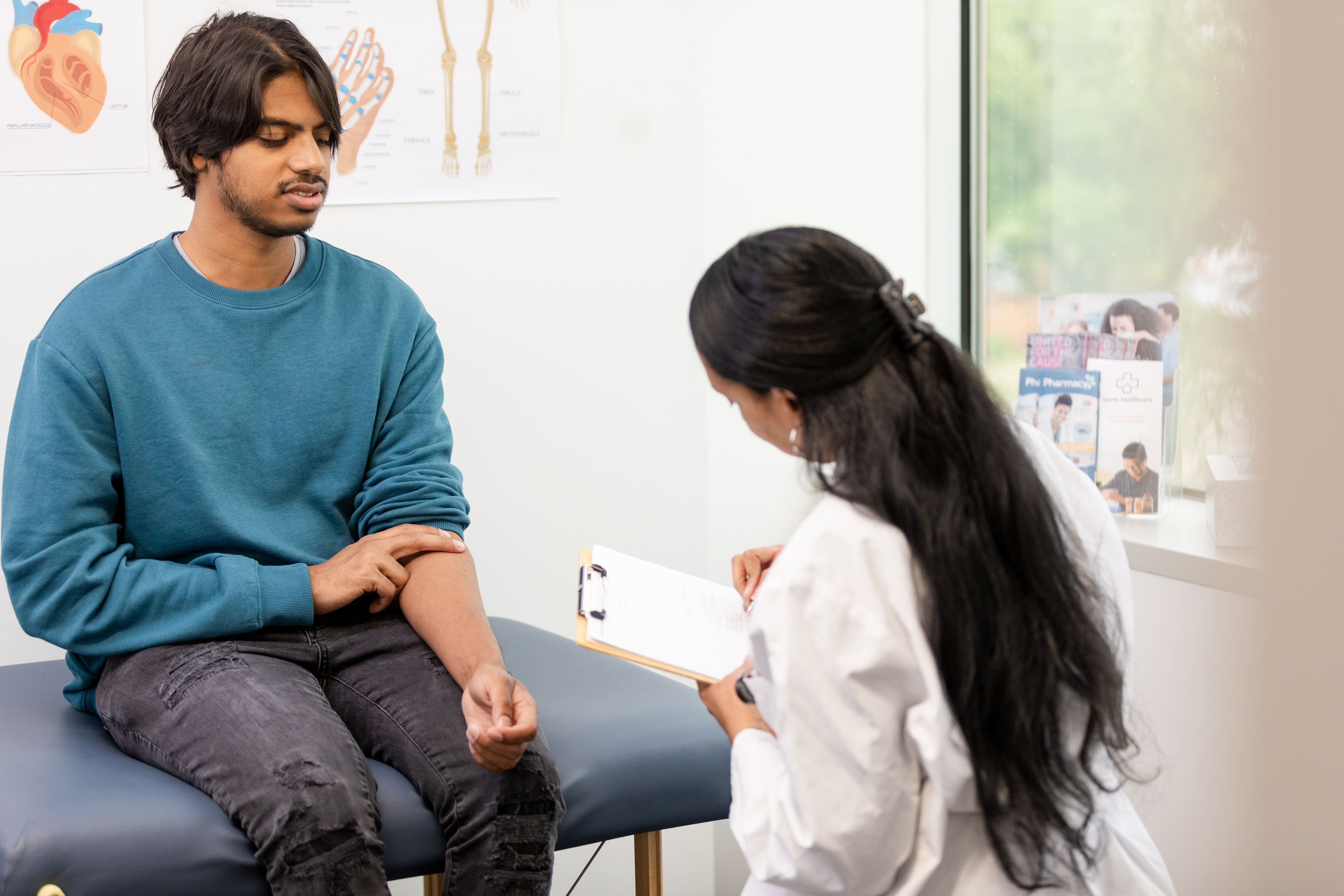 Doctor writing notes with a patient