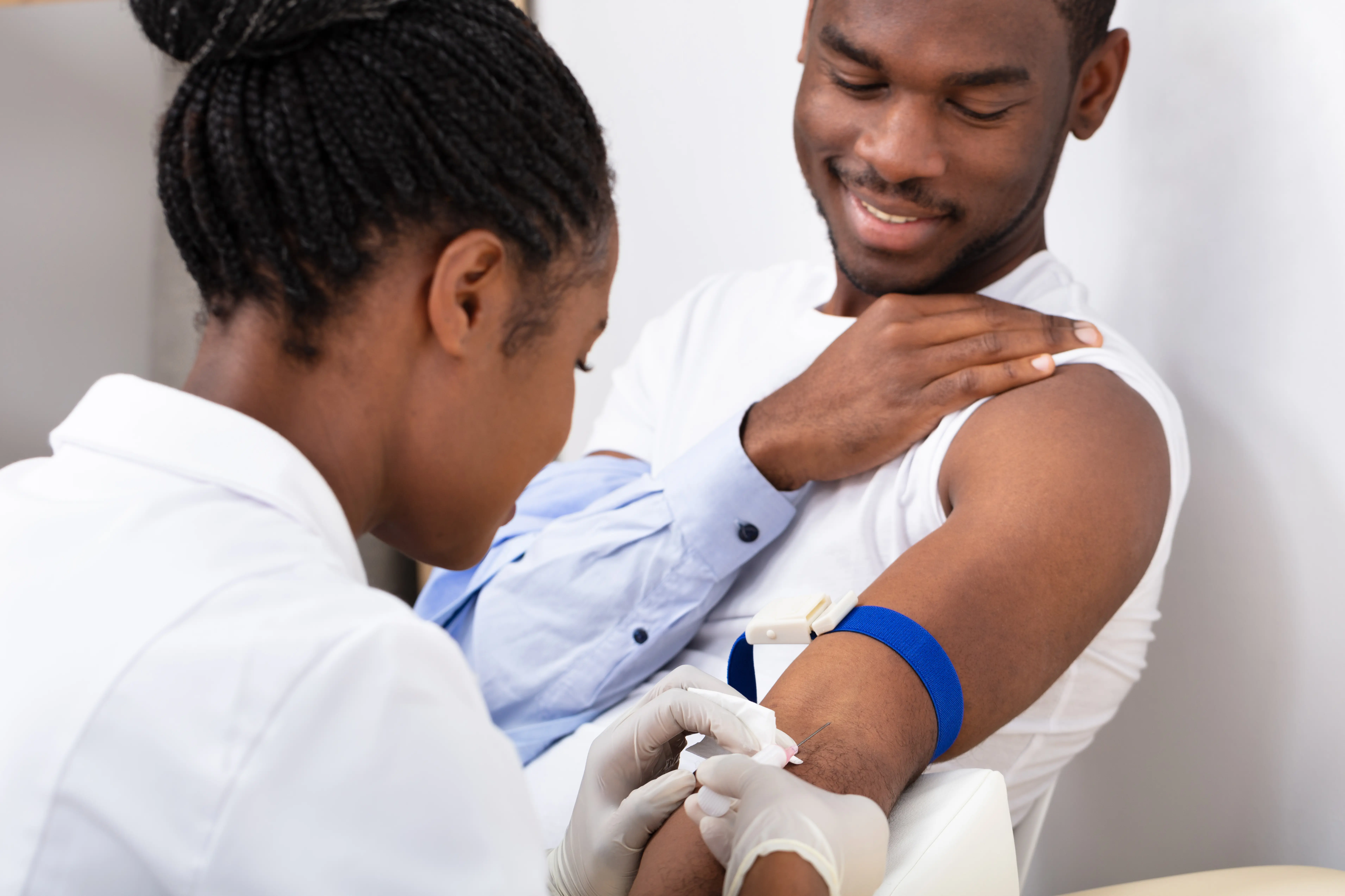 Doctor taking a blood sample from patients arm