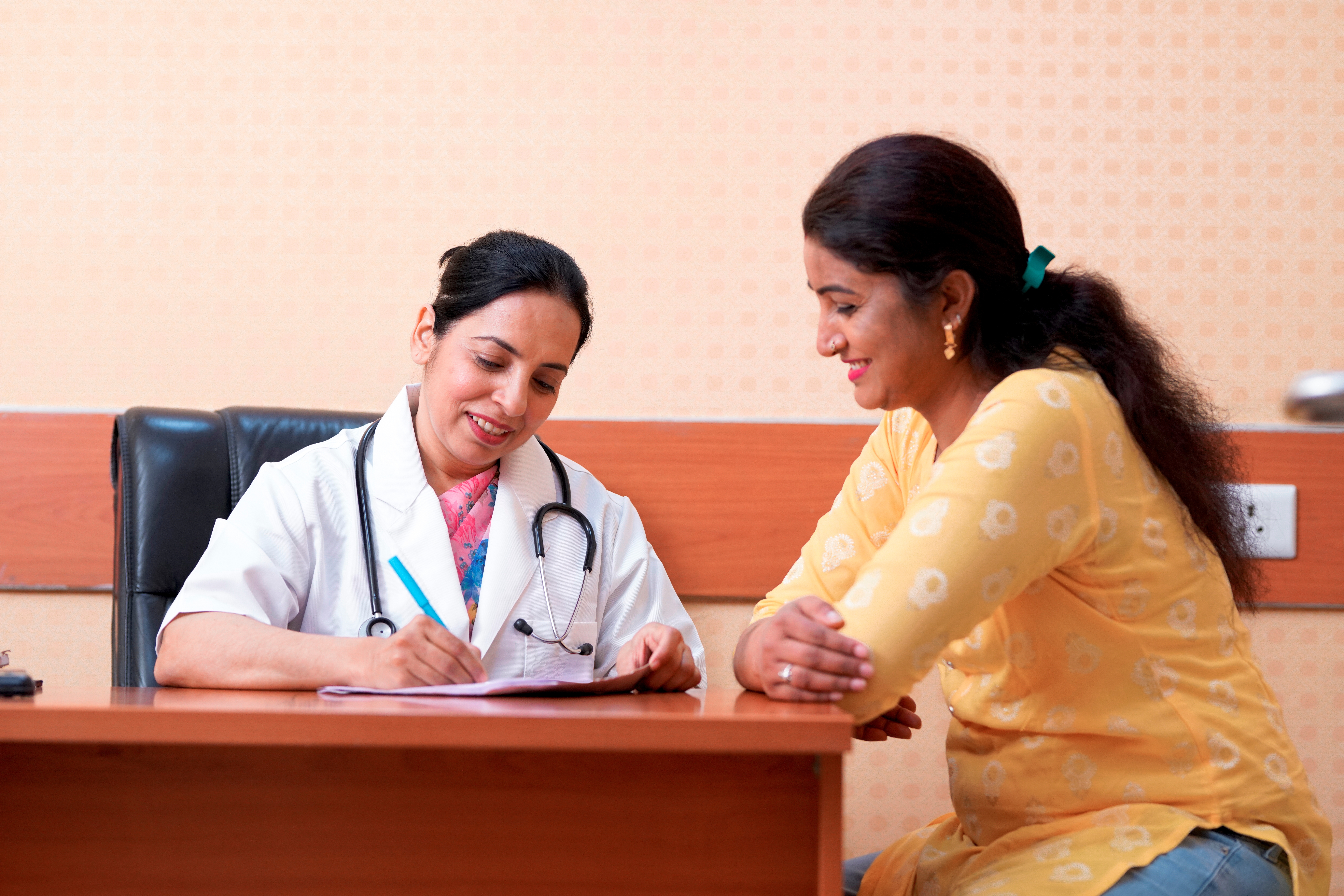 Doctor writing notes with a female patient